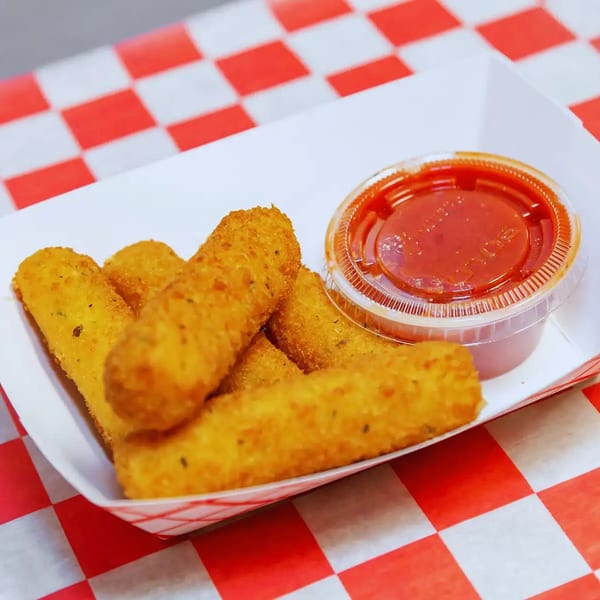 Golden fried mozzarella sticks with a side of marinara sauce in a white paper tray.