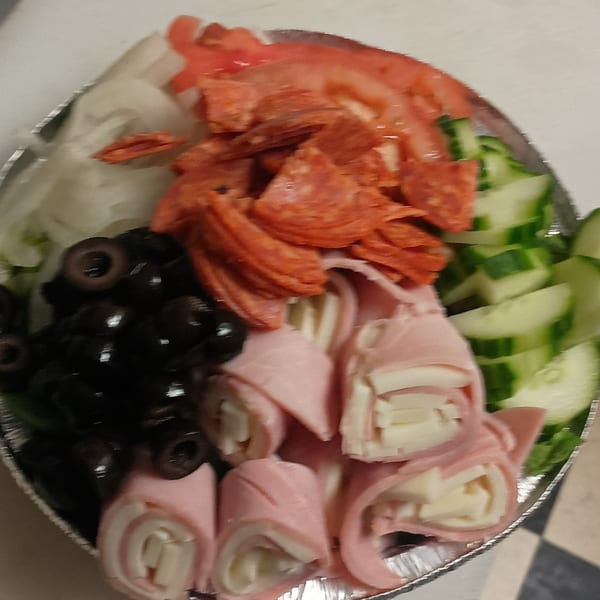 A Checkers Pizza antipasto salad with ham and cheese rolls, pepperoni, olives, tomatoes, and cucumbers.