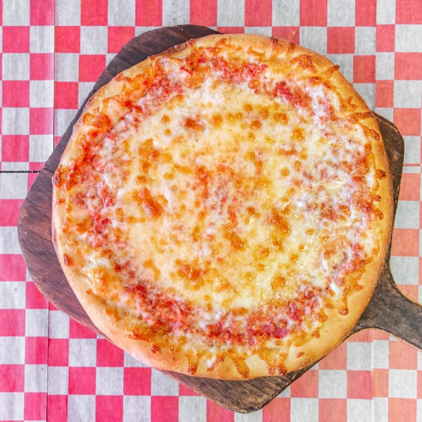 Checkers Pizza cheese pizza on a wooden peel, on red and white checkered paper.